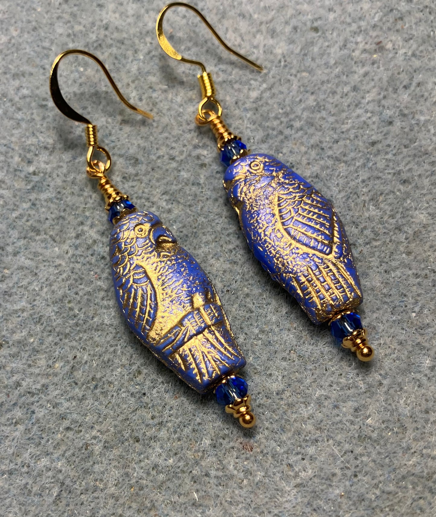 Large blue (with gold wash) Czech glass parrot bead earrings adorned with blue Chinese crystal beads.