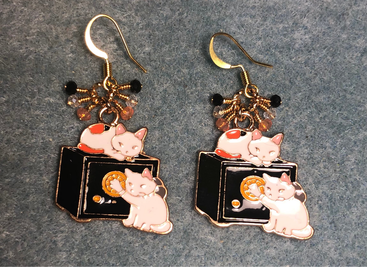 White, black, and orange enamel cat charm earrings adorned with tiny dangling white, black, and orange Chinese crystal beads.