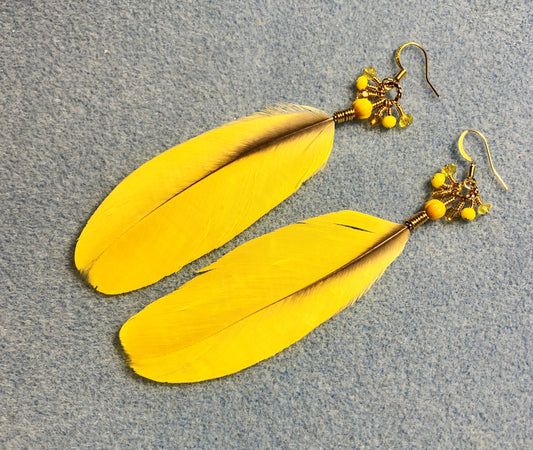 Yellow macaw feather earrings adorned with small dangling yellow and amber Czech glass beads.