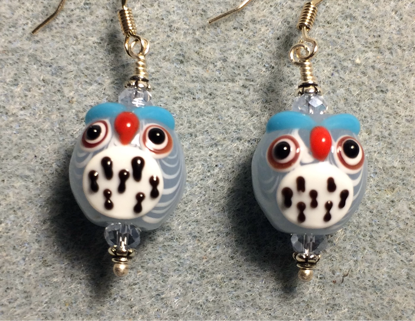 Light blue and white lamp work spotted owl bead earrings adorned with light blue Chinese crystal beads.