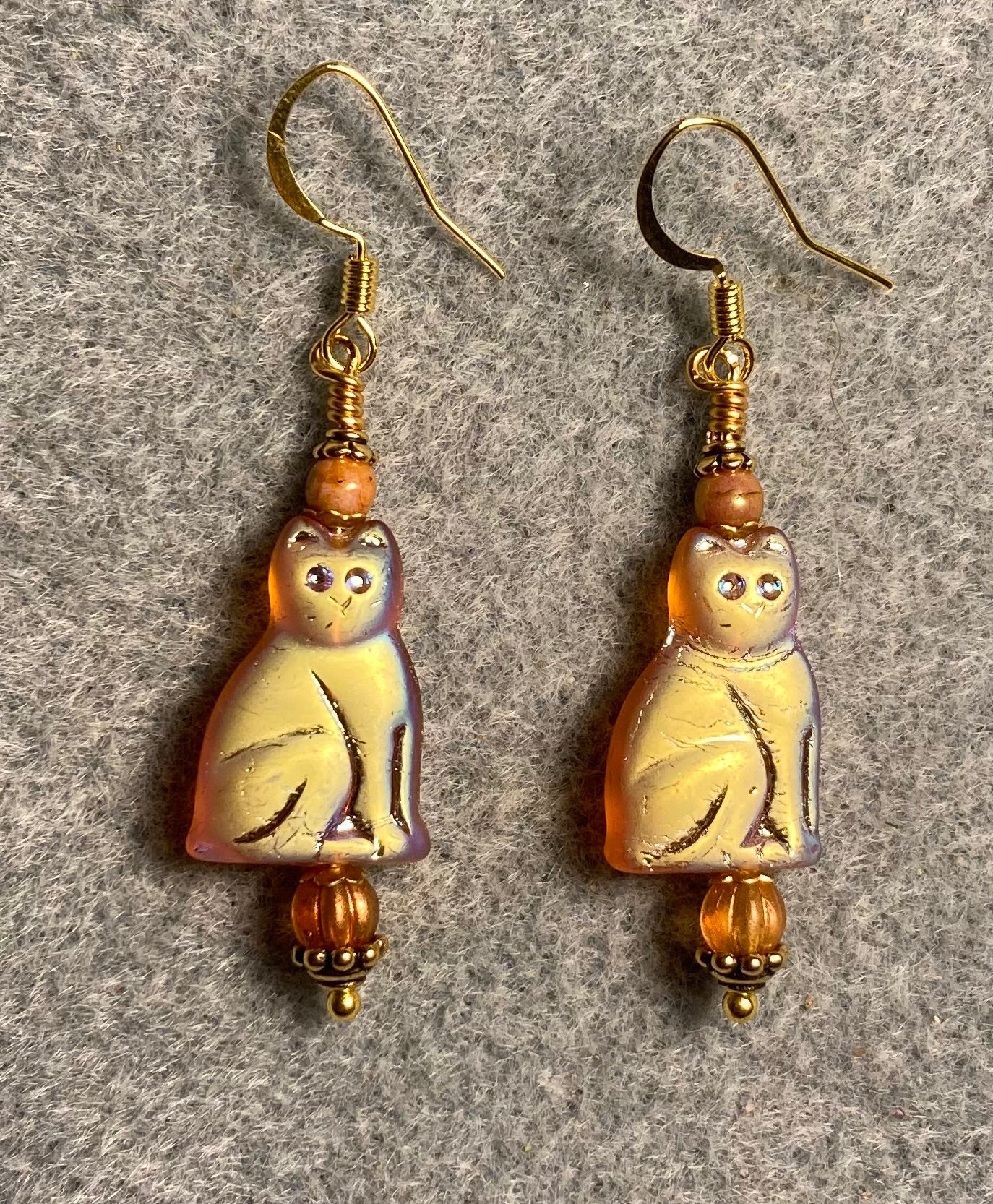 Metallic orange Czech glass cat bead earrings adorned with orange Czech glass beads.