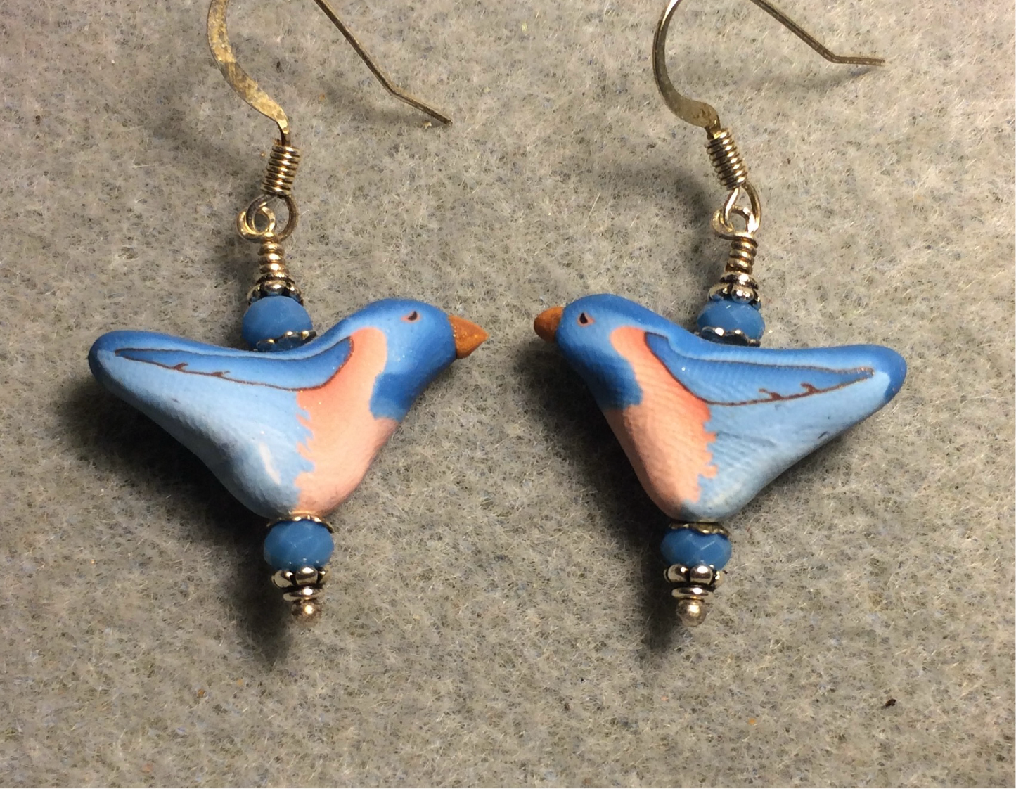 Blue and peach polymer clay bird bead earrings adorned with blue Chinese crystal beads.