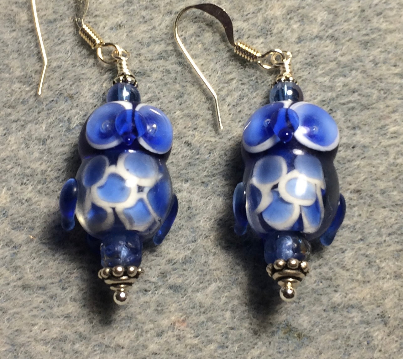 Bright blue lamp work owl bead earrings adorned with blue Czech glass beads.
