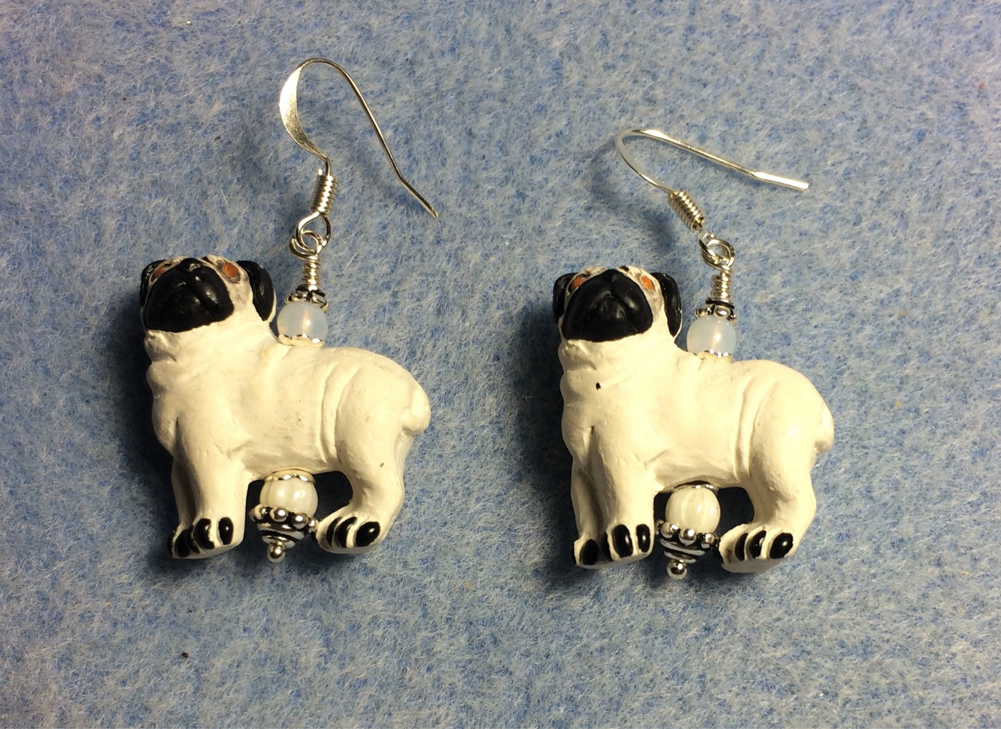 White and black ceramic pug bead earrings adorned with white Czech glass beads.