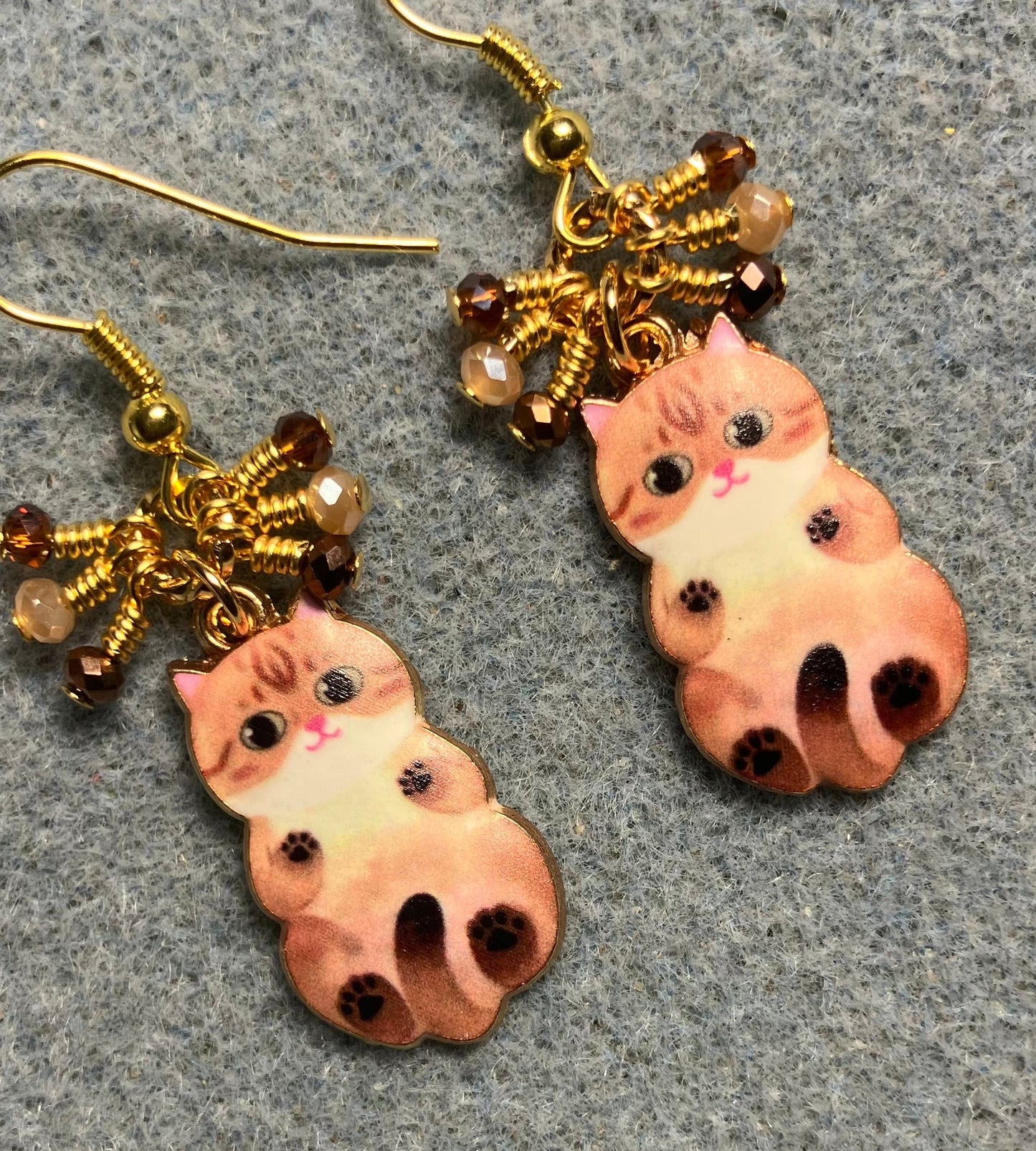 Brown and tan enamel cat charm earrings adorned with tiny dangling brown, tan, and amber Chinese crystal beads.