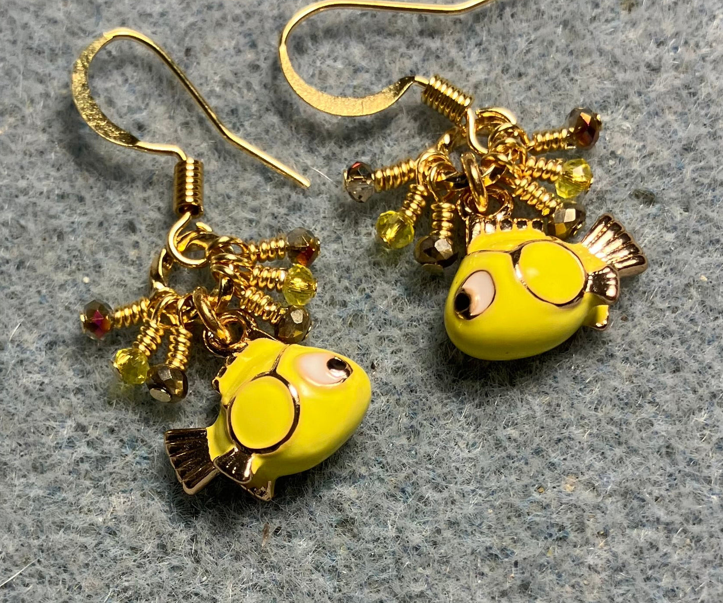Tiny yellow and black enamel fish charm earrings adorned with tiny dangling yellow and gold Chinese crystal beads.