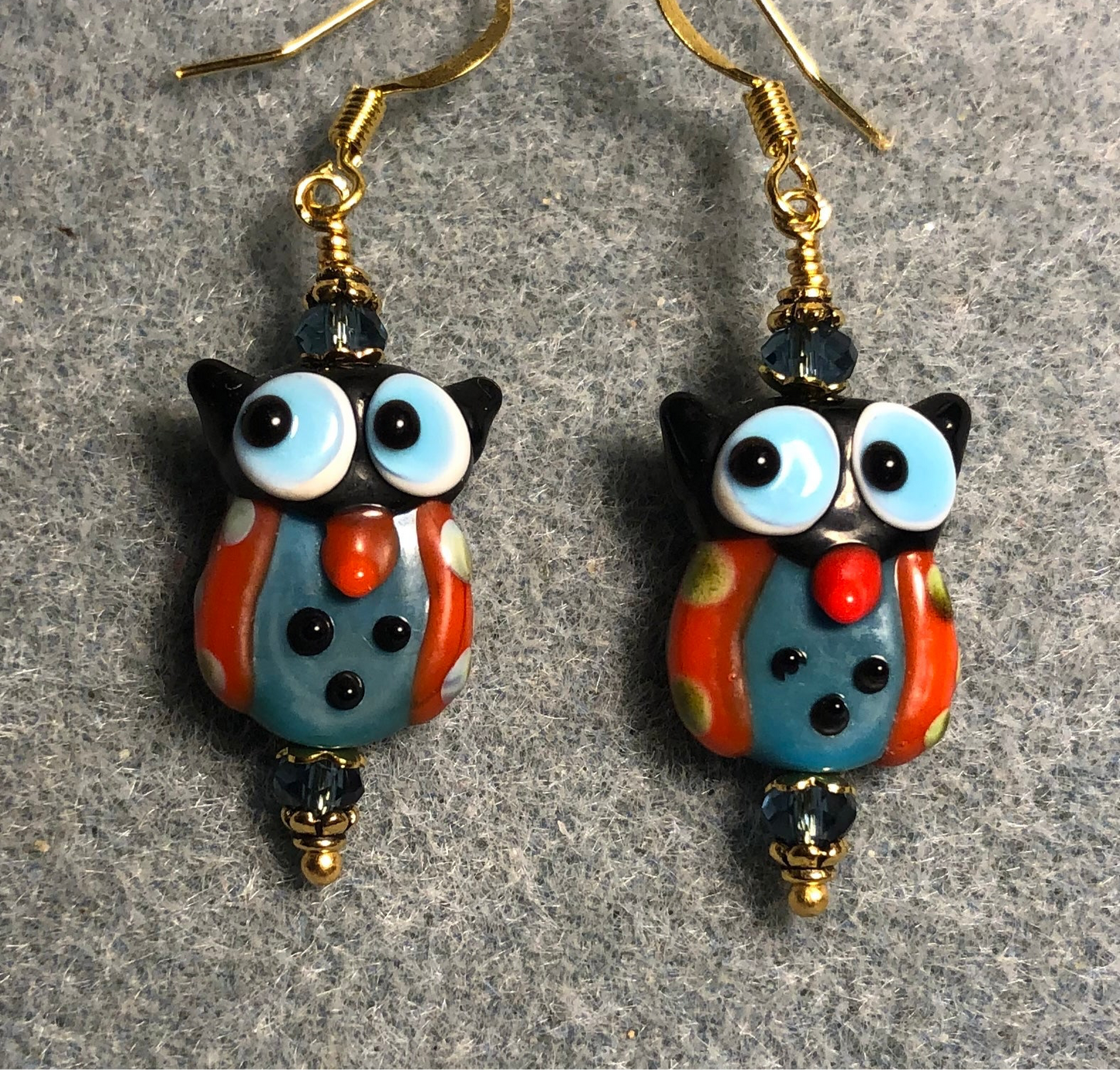 Red and blue lamp work owl bead earrings adorned with blue Chinese crystal beads.