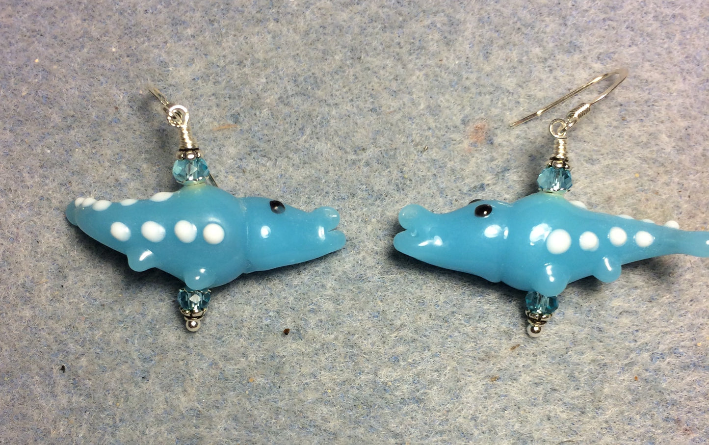 Milky turquoise lamp work spotted alligator bead earrings adorned with turquoise Chinese crystal beads.