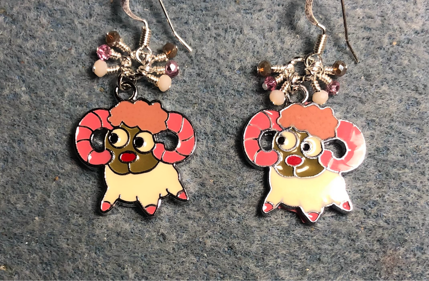Off white, pink, and brown enamel ram charm earrings adorned with tiny dangling off white, pink, and brown Czech glass beads.