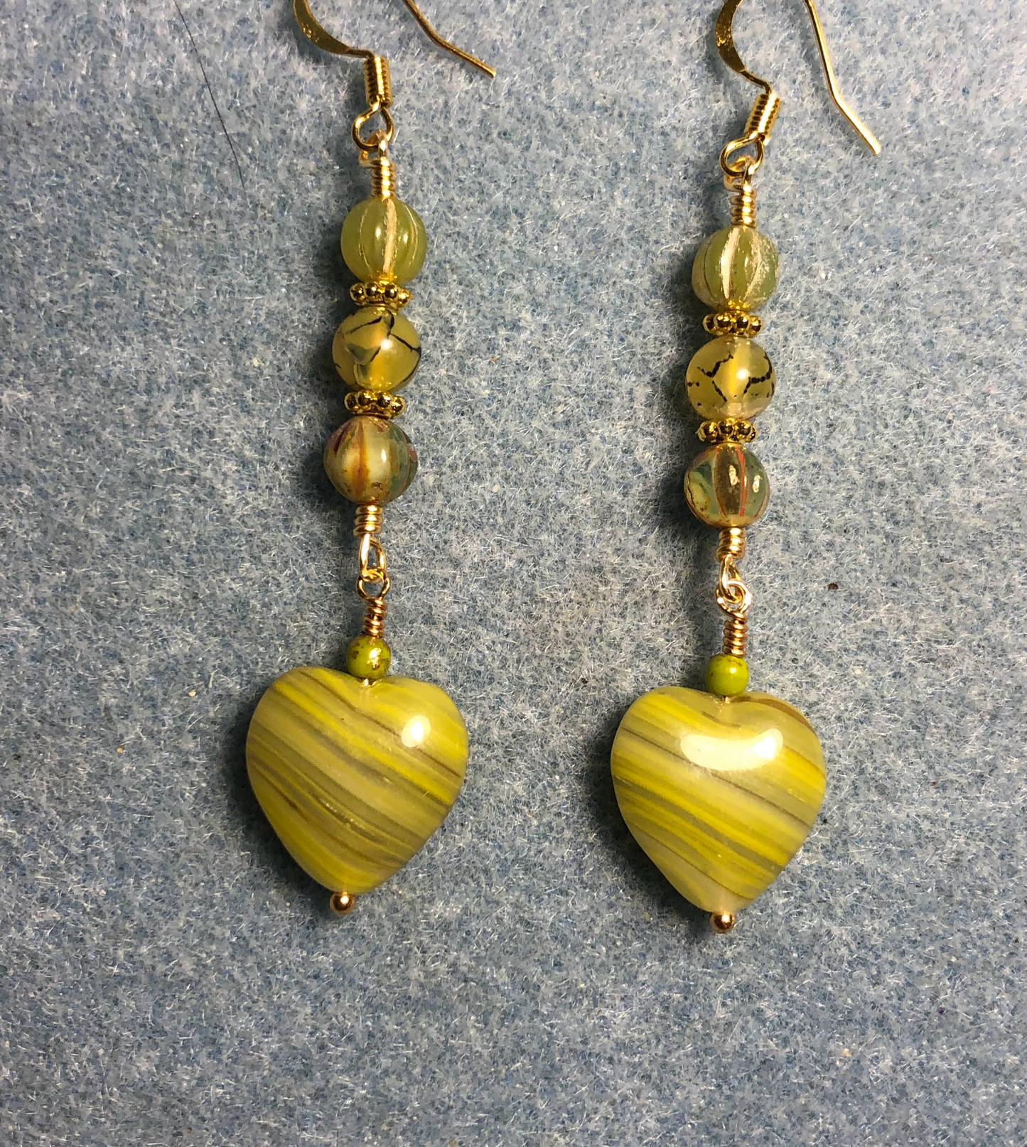 Opaque striped olive green Czech glass heart bead earrings adorned with olive green Czech glass beads.