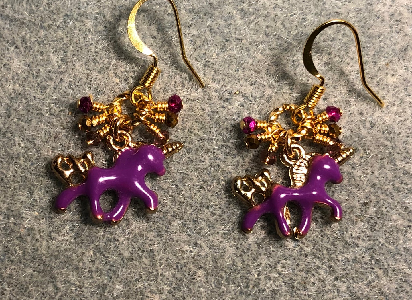 Tiny purple and gold enamel unicorn charm earrings adorned with tiny dangling purple and gold Chinese crystal beads.