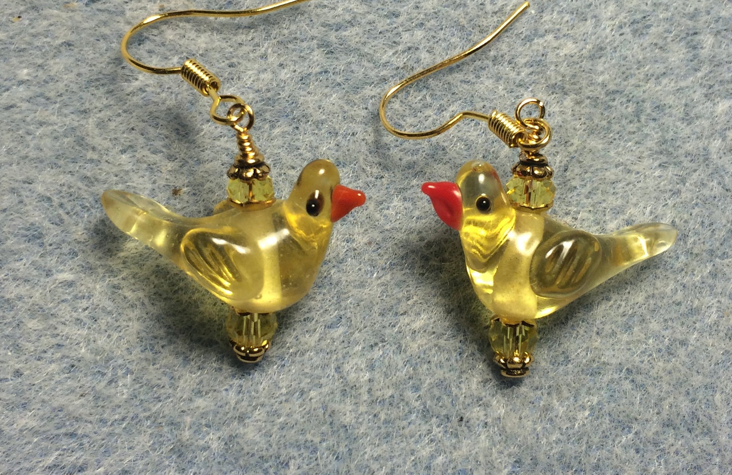 Translucent yellow lamp work songbird bead earrings adorned with yellow Chinese crystal beads.