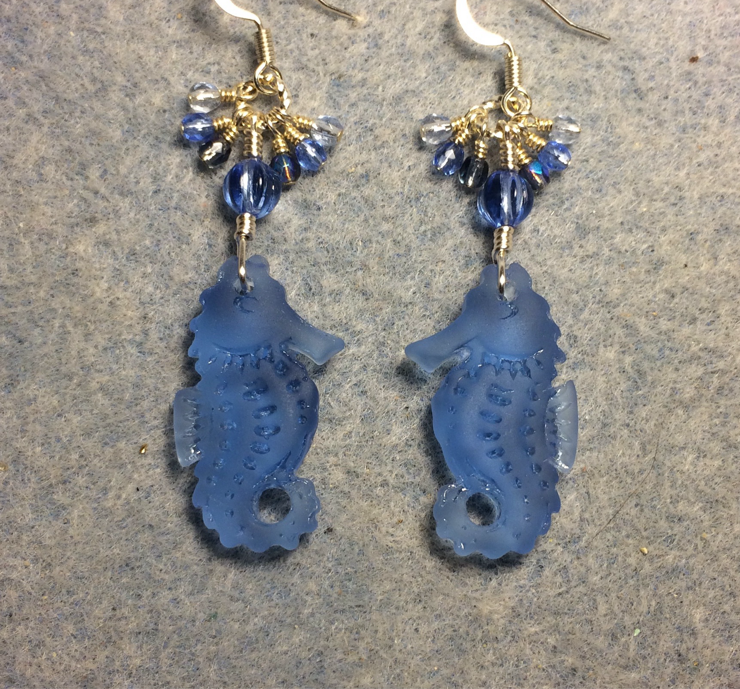 Light blue sea glass seahorse pendant bead earrings adorned with light blue Czech glass beads and small dangling light blue Czech glass beads.
