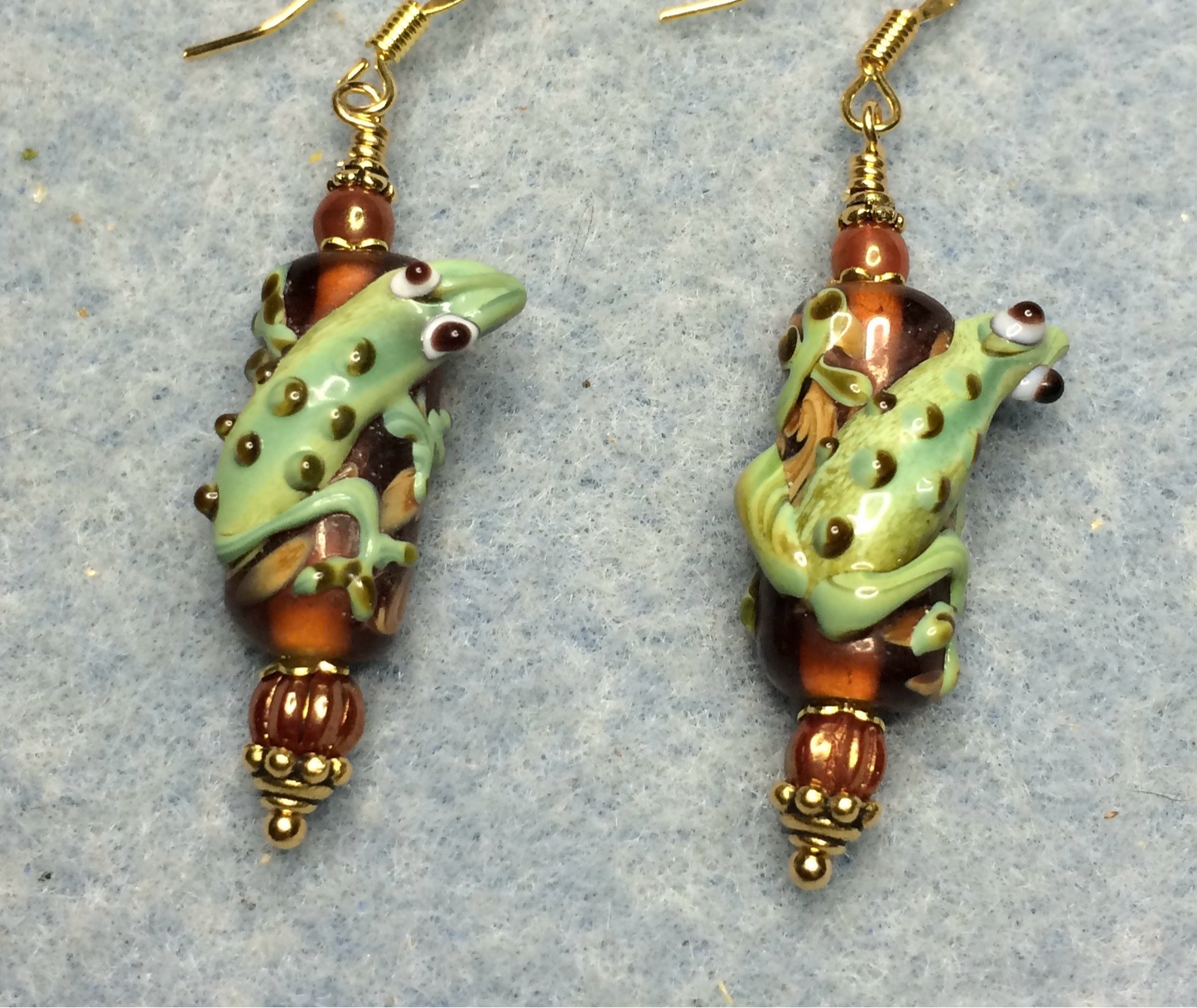Orange and green lamp work lizard bead earrings adorned with orange Czech glass beads.