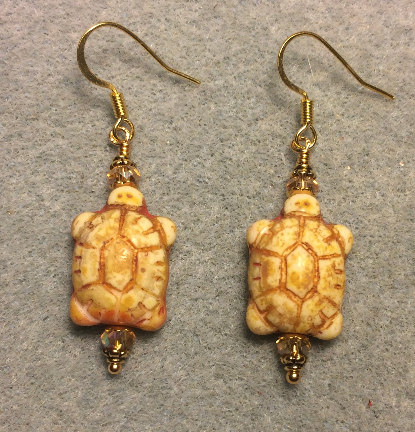 Cream alabaster Czech glass turtle bead earrings adorned with topaz Chinese crystal beads.