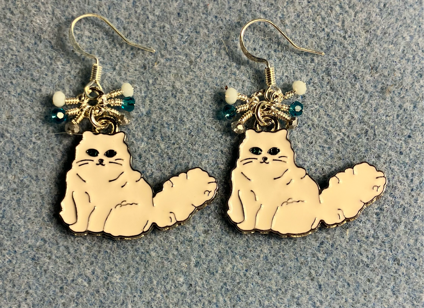 White and silver enamel Persian cat charm earrings adorned with tiny dangling white, turquoise, and silver Chinese crystal beads.