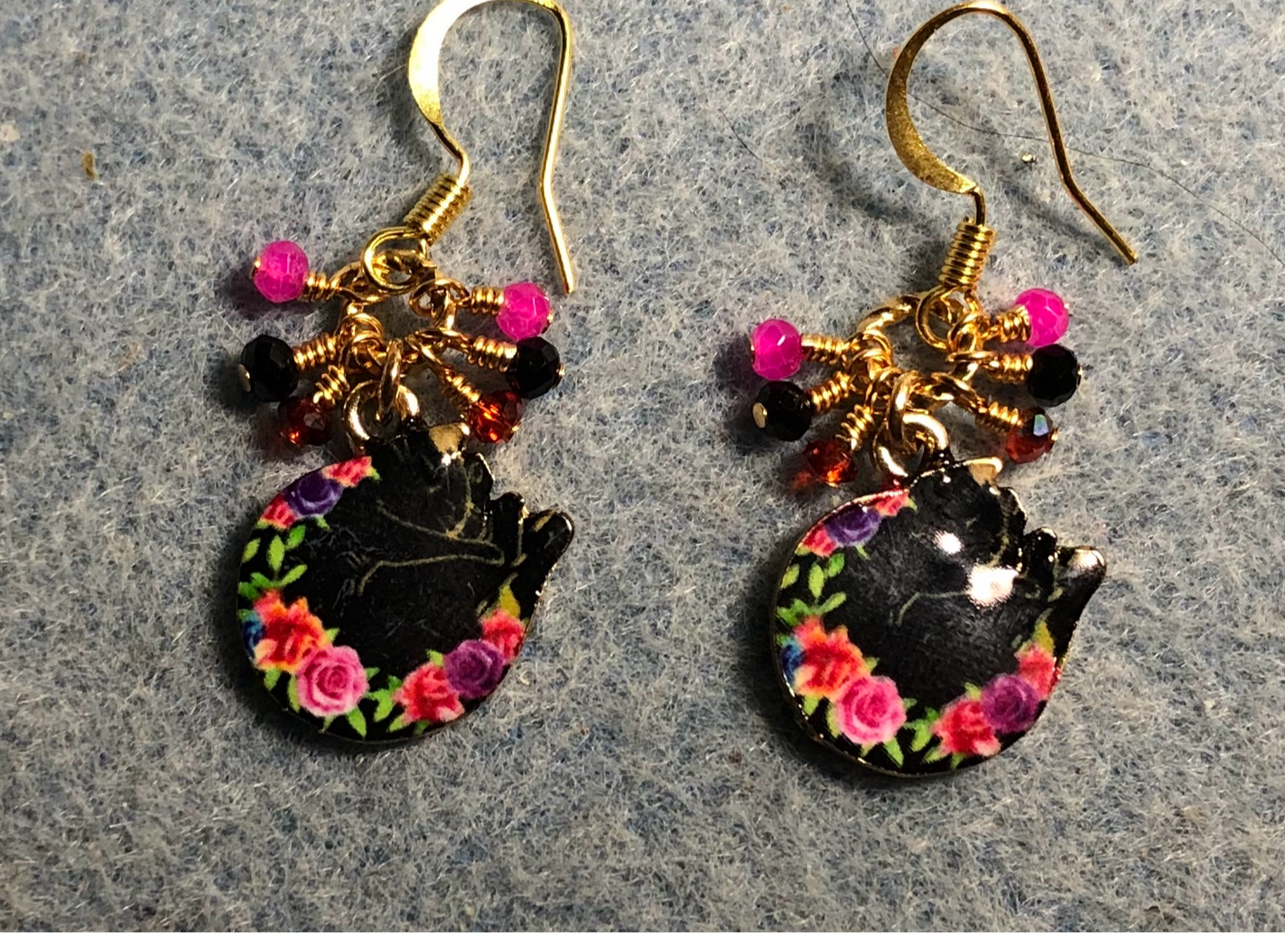 Black, red, and pink enamel sleeping cat charm earrings adorned with tiny dangling black, red, and pink Chinese crystal beads.