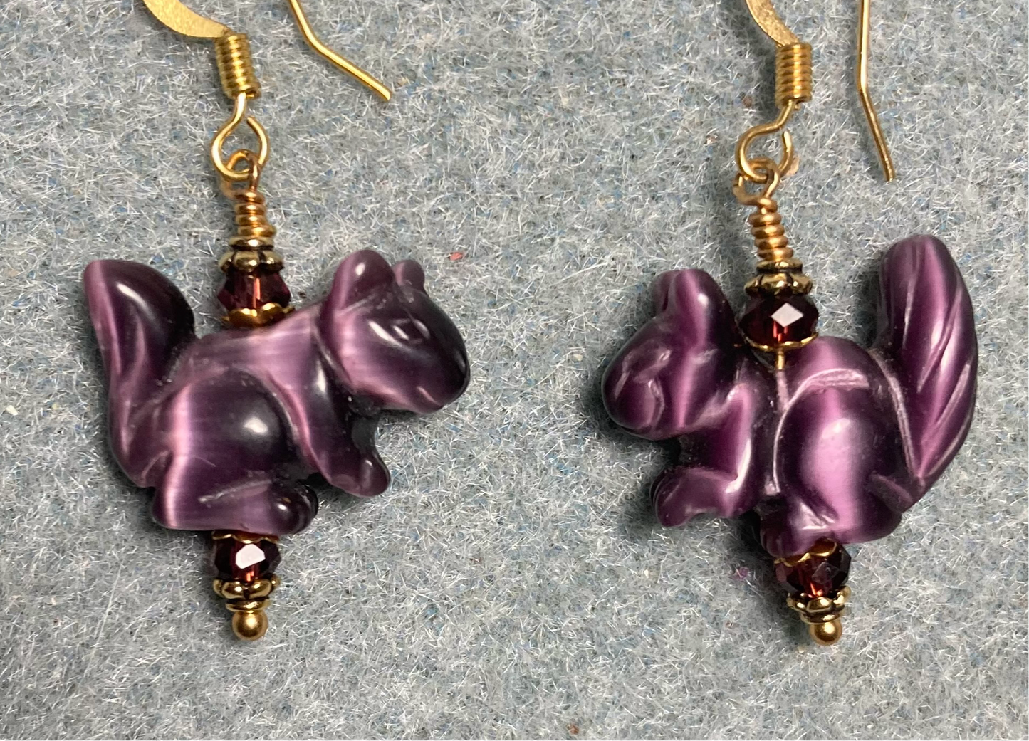 Purple fiber optic (cat’s eye) squirrel bead earrings adorned with purple Chinese crystal beads.