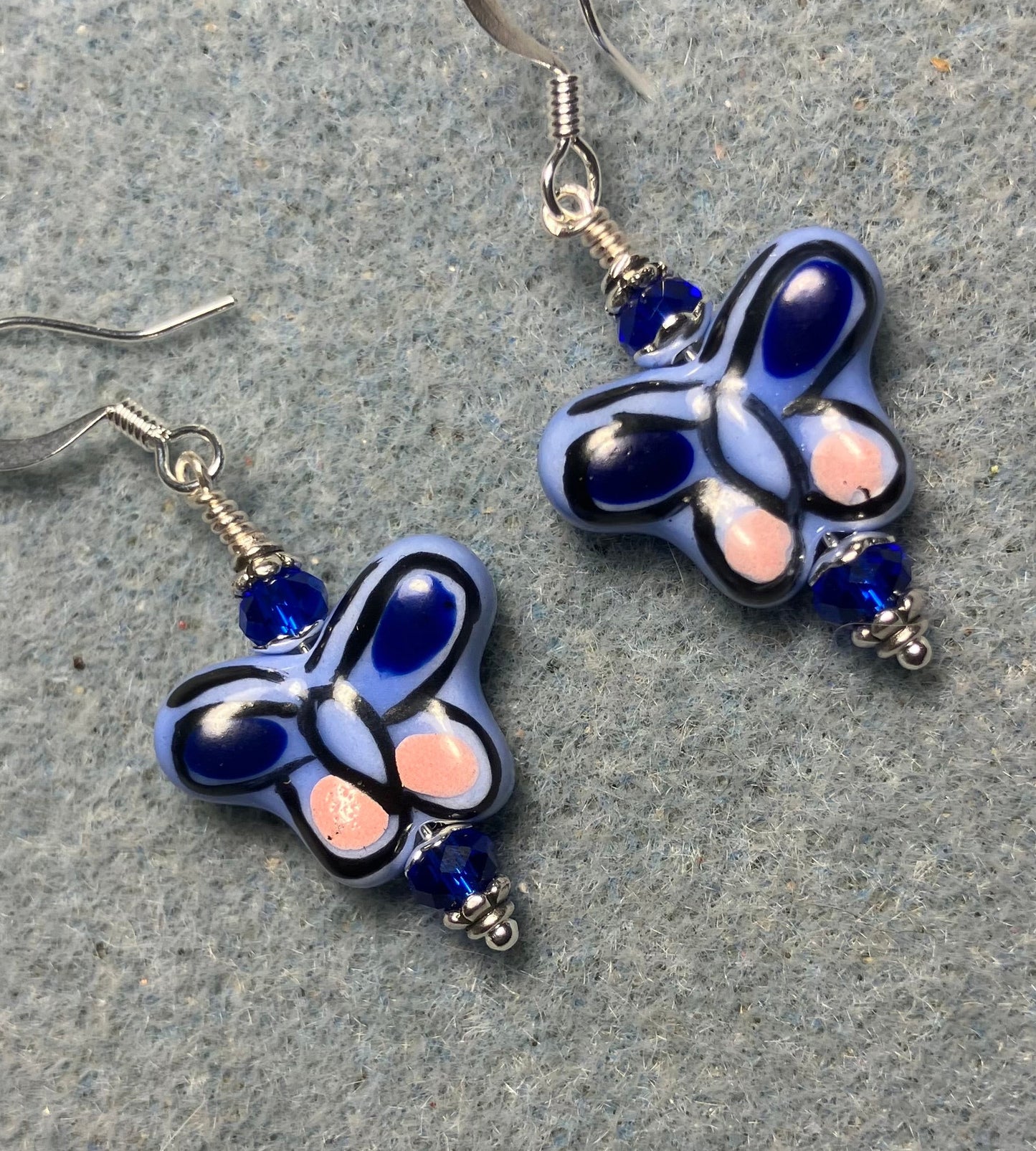 Blue and pink ceramic butterfly bead earrings adorned with dark blue Chinese crystal beads.