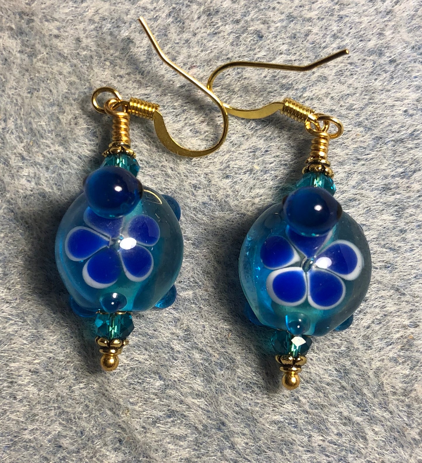 Dark turquoise and dark blue lamp work turtle bead earrings adorned with turquoise Chinese crystal beads.