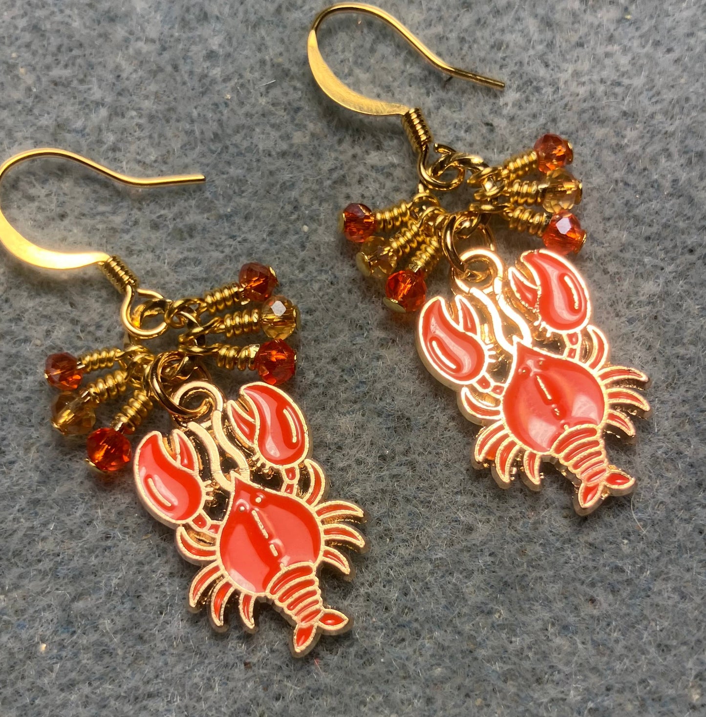Orange enamel lobster charm earrings adorned with tiny dangling orange and amber Chinese crystal beads.