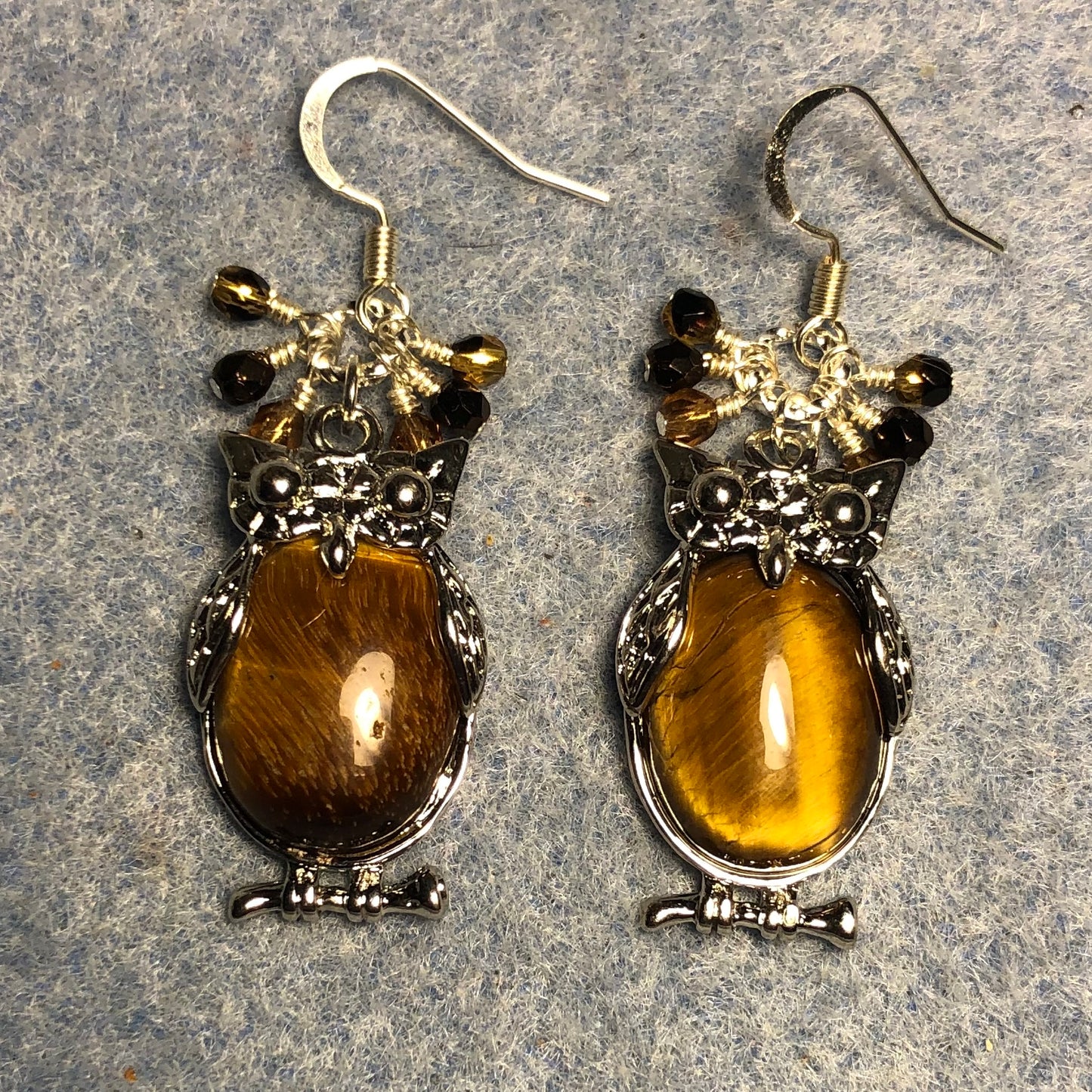 Large silver and brown tigereye gemstone owl charm earrings adorned with small dangling brown and amber Czech glass beads.