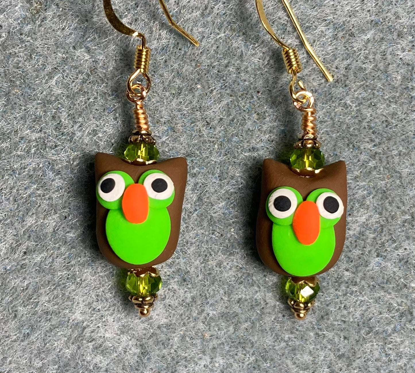 Brown, olive green, and orange polymer clay bird bead earrings adorned with olive green Chinese crystal beads.