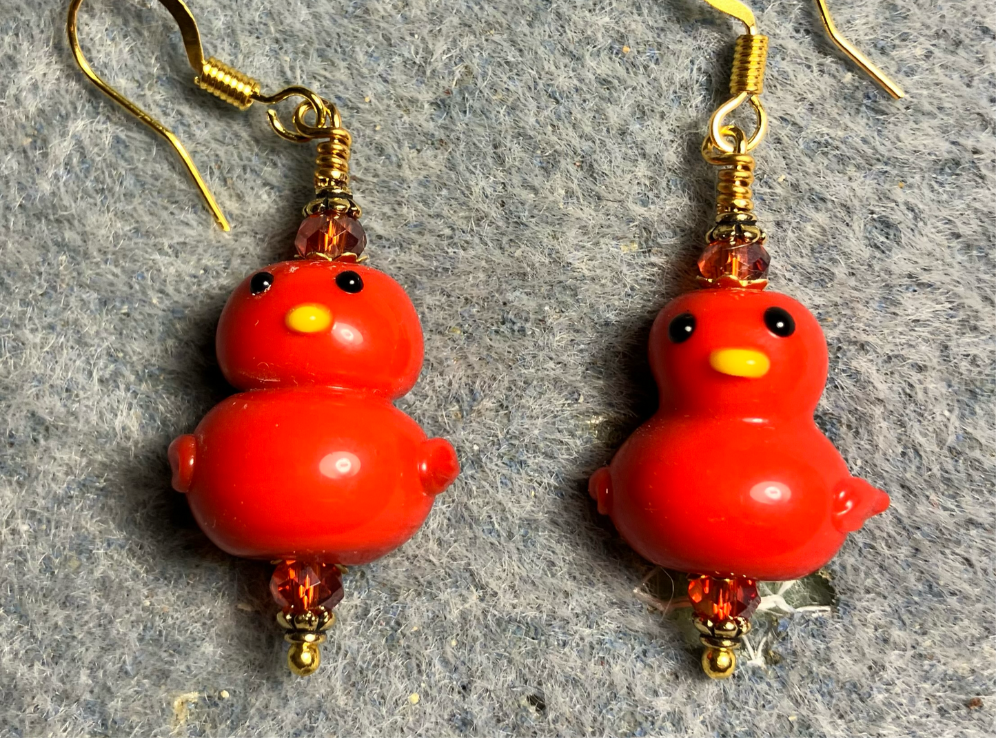 Opaque red lamp work duck bead earrings adorned with red Chinese crystal beads.