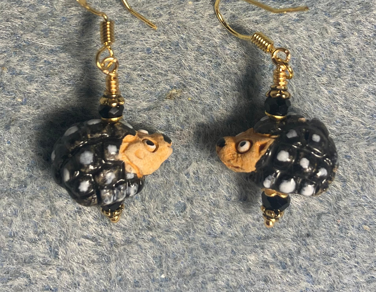 Small black, white, and tan ceramic hedgehog bead earrings adorned with black Chinese crystal beads.