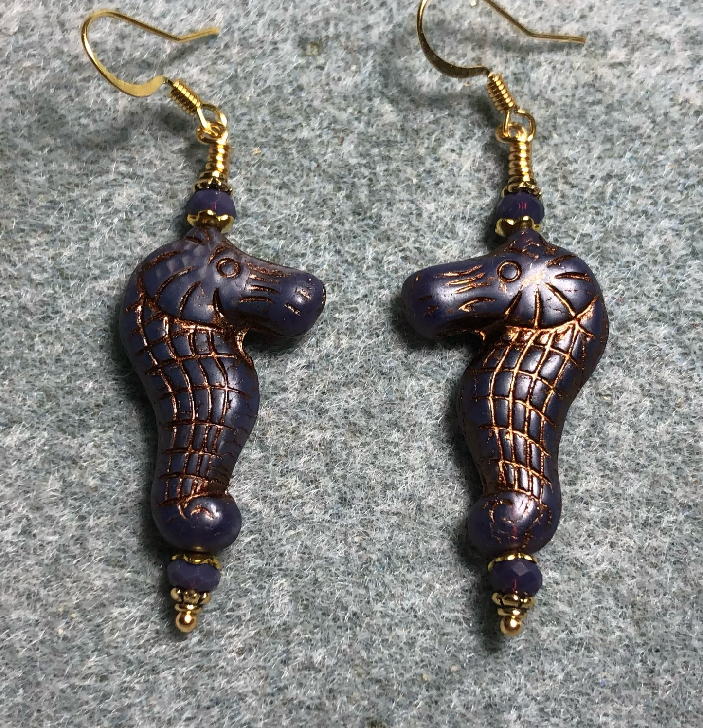 Dark purple (with copper inlay) Czech glass seahorse bead earrings adorned with purple Chinese crystal beads.