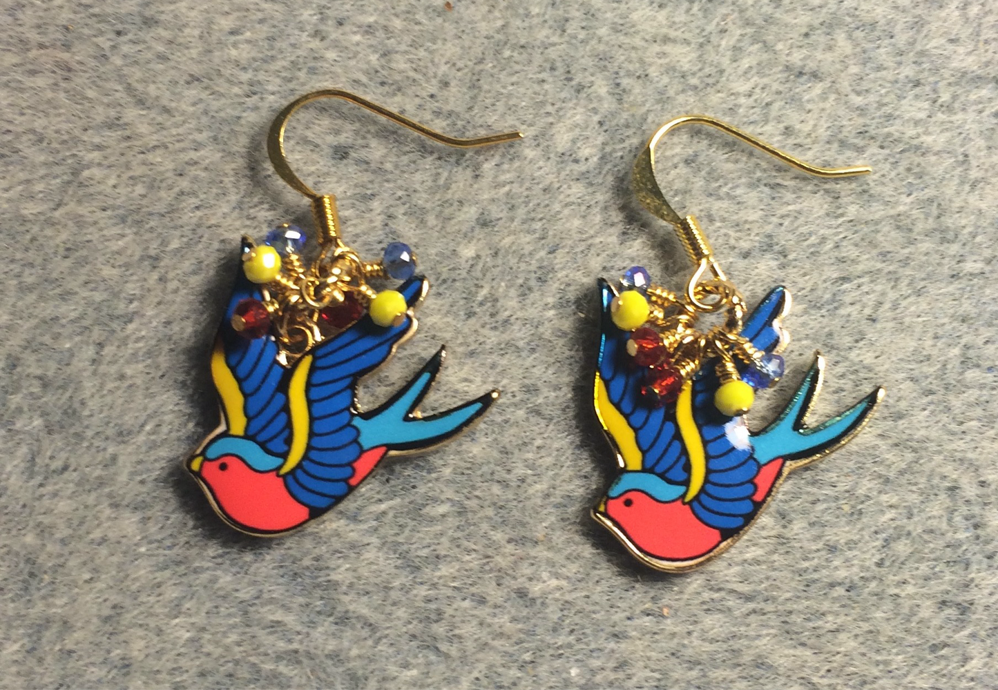 Blue, yellow, and red enamel flying dove charm earrings adorned with tiny dangling blue, yellow, and red Chinese crystal beads.