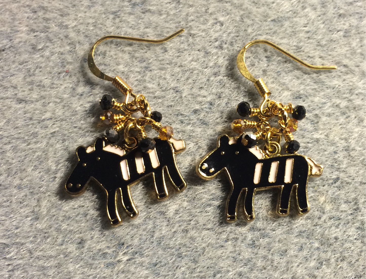 Black and white enamel horse charm earrings adorned with tiny dangling black and amber Chinese crystal beads.