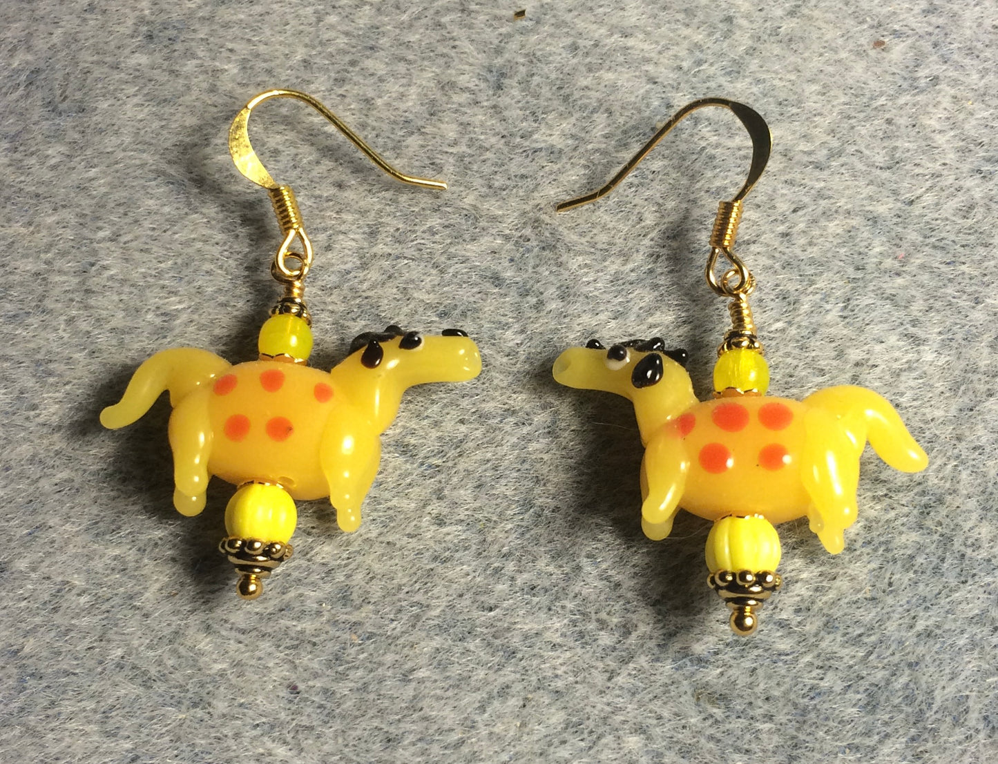 Opaque golden yellow and red lamp work spotted horse bead earrings adorned with yellow Czech glass beads.