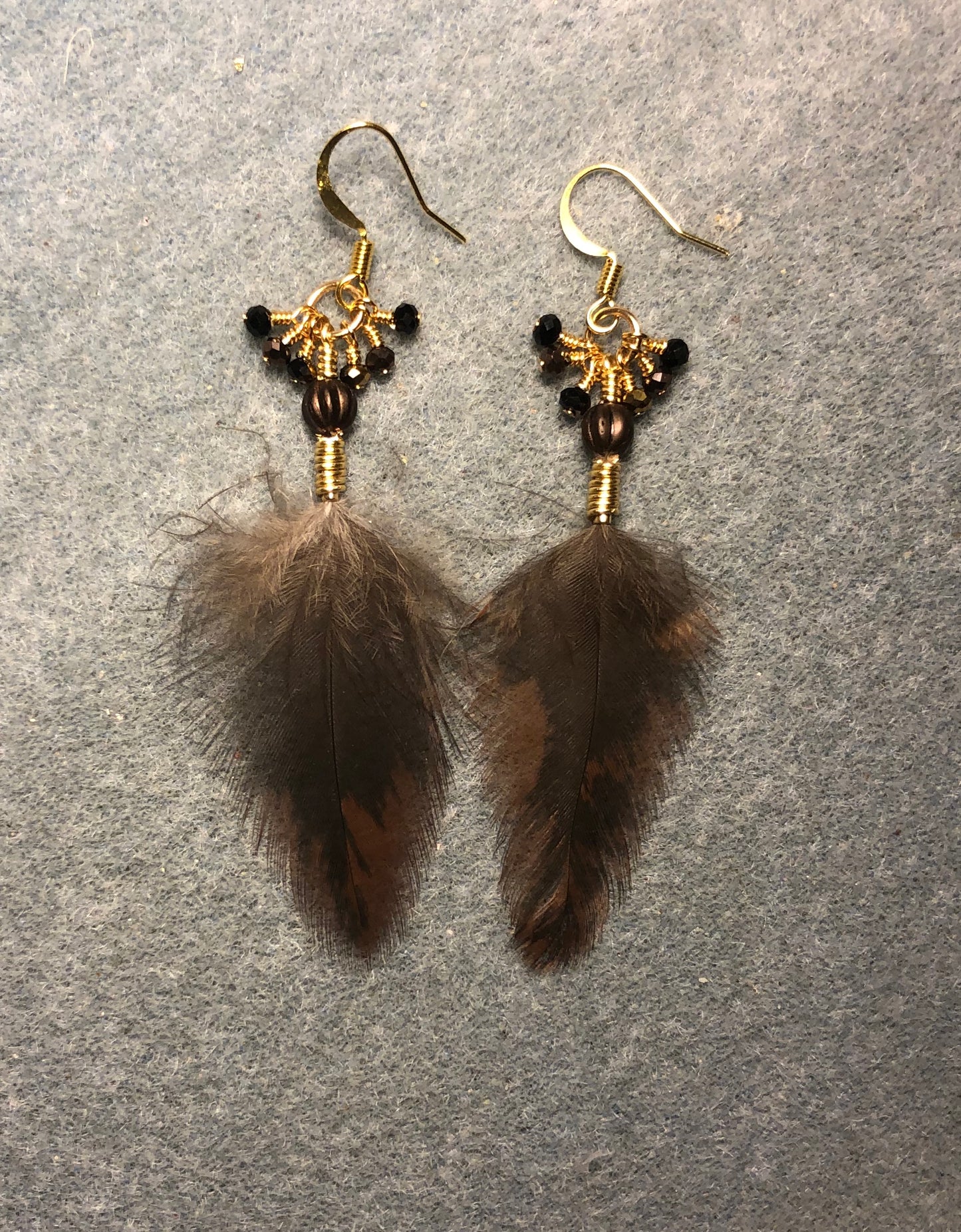 Brown and black Americana hen feather earrings adorned with brown Czech glass melon beads and tiny dangling brown and black Chinese crystal beads.