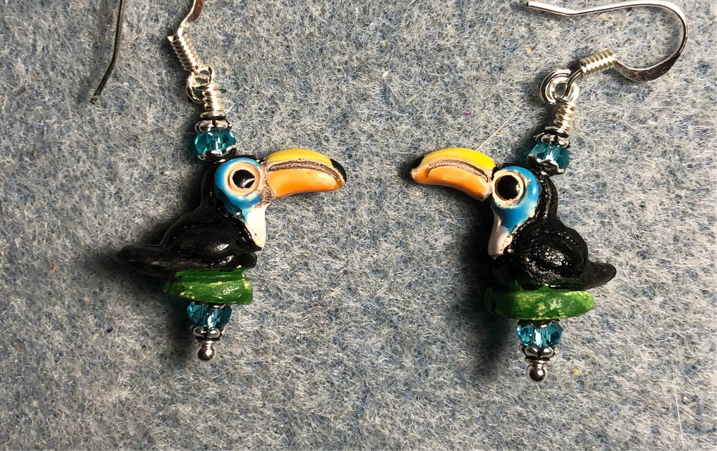 Small black, orange, and turquoise ceramic toucan bead earrings adorned with turquoise Chinese crystal beads.