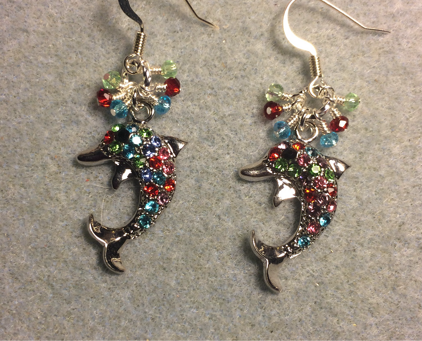 Silver and colorful rhinestone dolphin charm earrings adorned with tiny dangling turquoise, red, and light green Chinese crystal beads.
