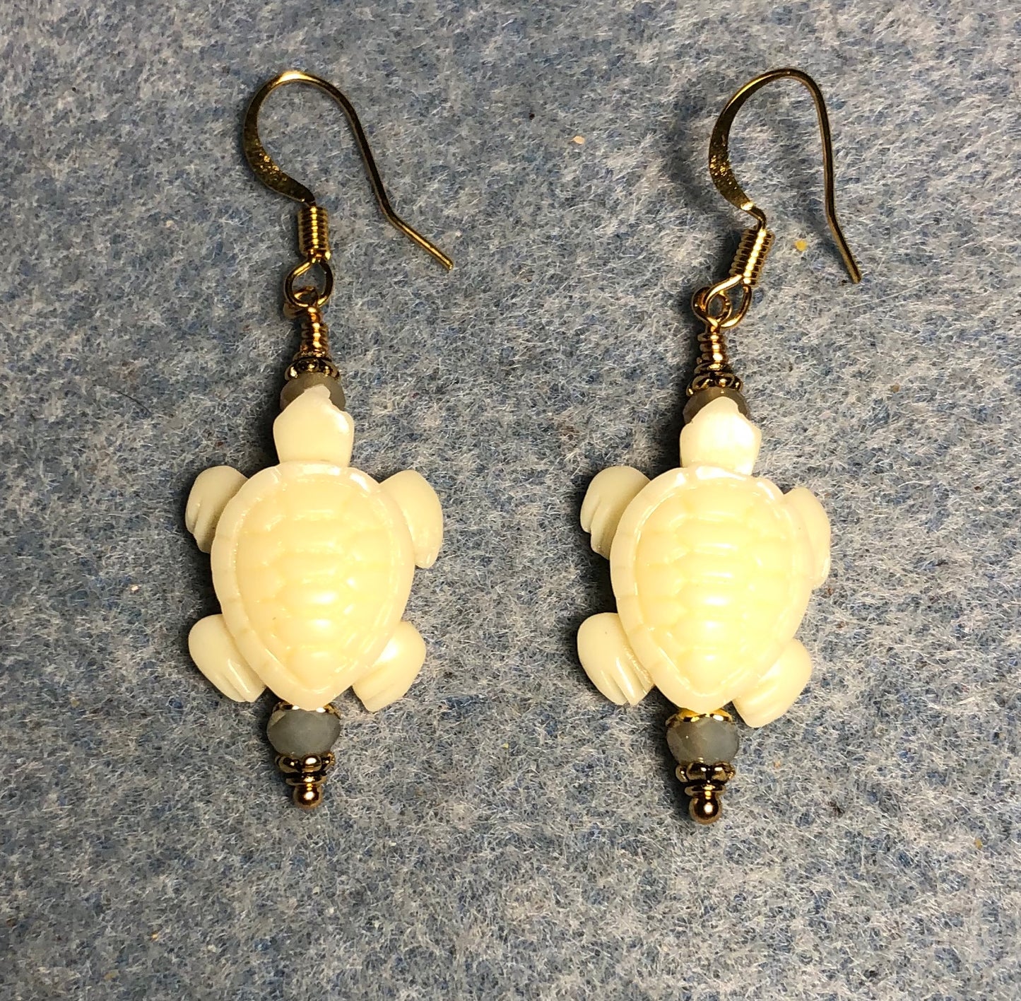 Off white resin turtle bead earrings adorned with beige Chinese crystal beads.