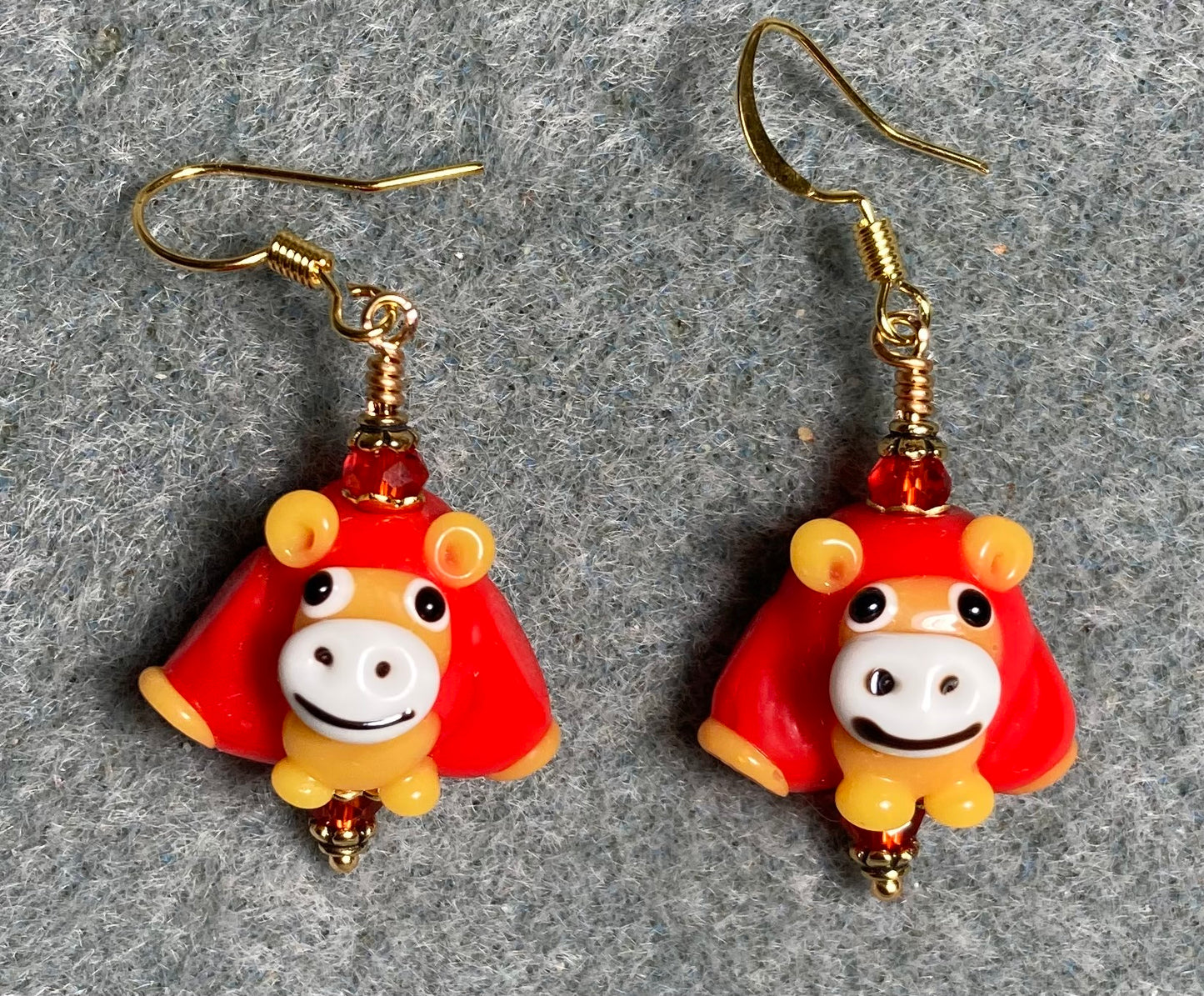 Opaque red, white, and yellow lamp work sheep bead earrings adorned with red Chinese crystal beads.