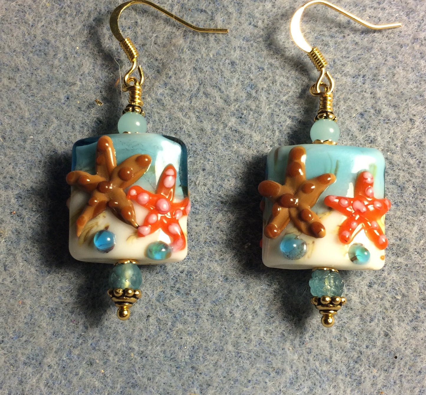 Light aqua, brown, and orange lamp work starfish bead earrings adorned with light aqua Czech glass beads.
