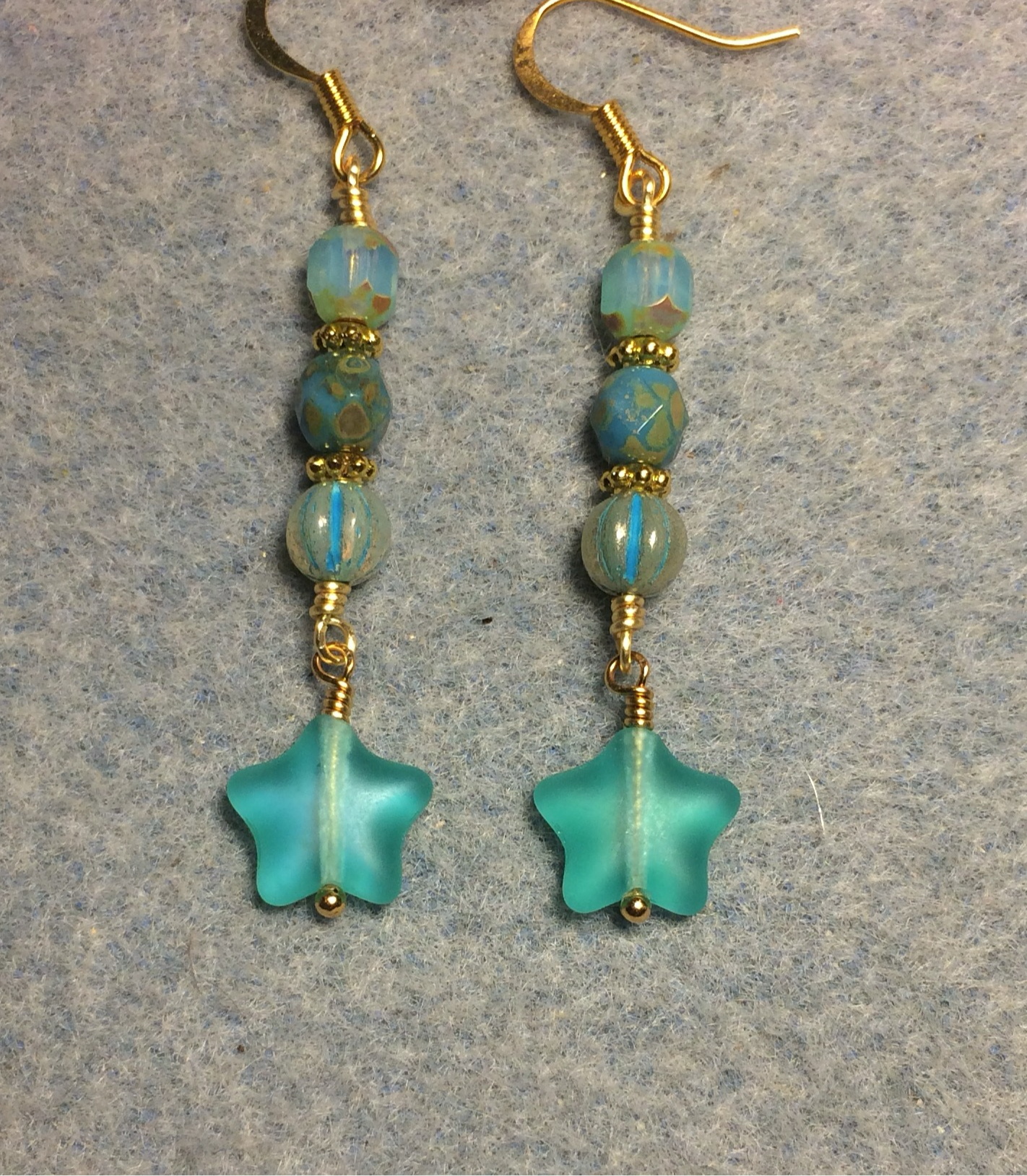 Small matte turquoise teal Czech glass star bead earrings adorned with turquoise teal Czech glass beads.