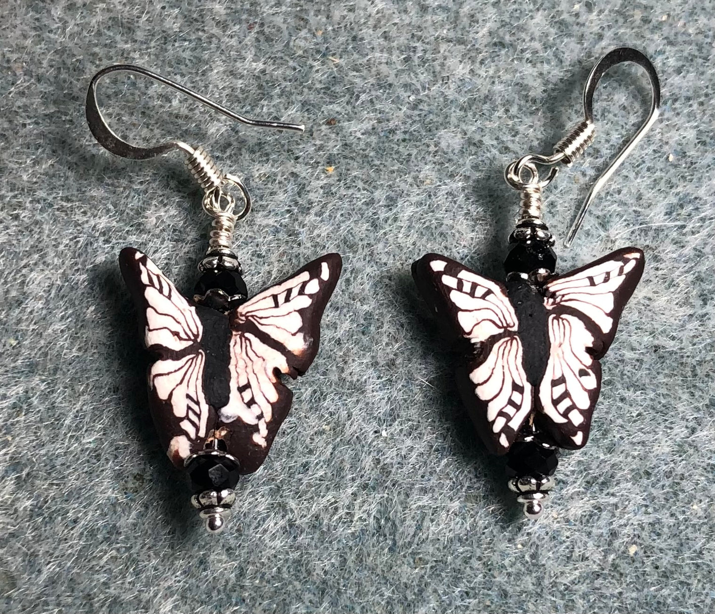 White and black polymer clay butterfly bead earrings adorned with black Chinese crystal beads.