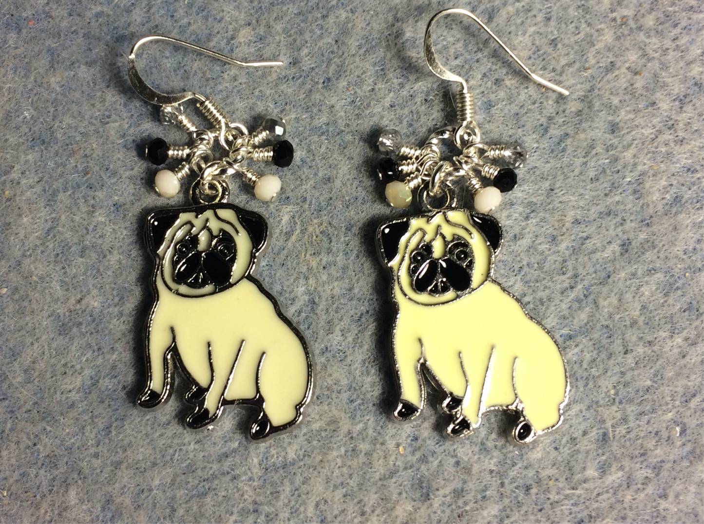 Off white and black enamel pug charm earrings adorned with tiny dangling white, black, and silver Chinese crystal beads.