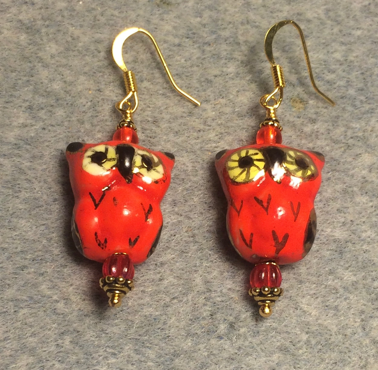 Red ceramic owl bead earrings adorned with red Czech glass beads.