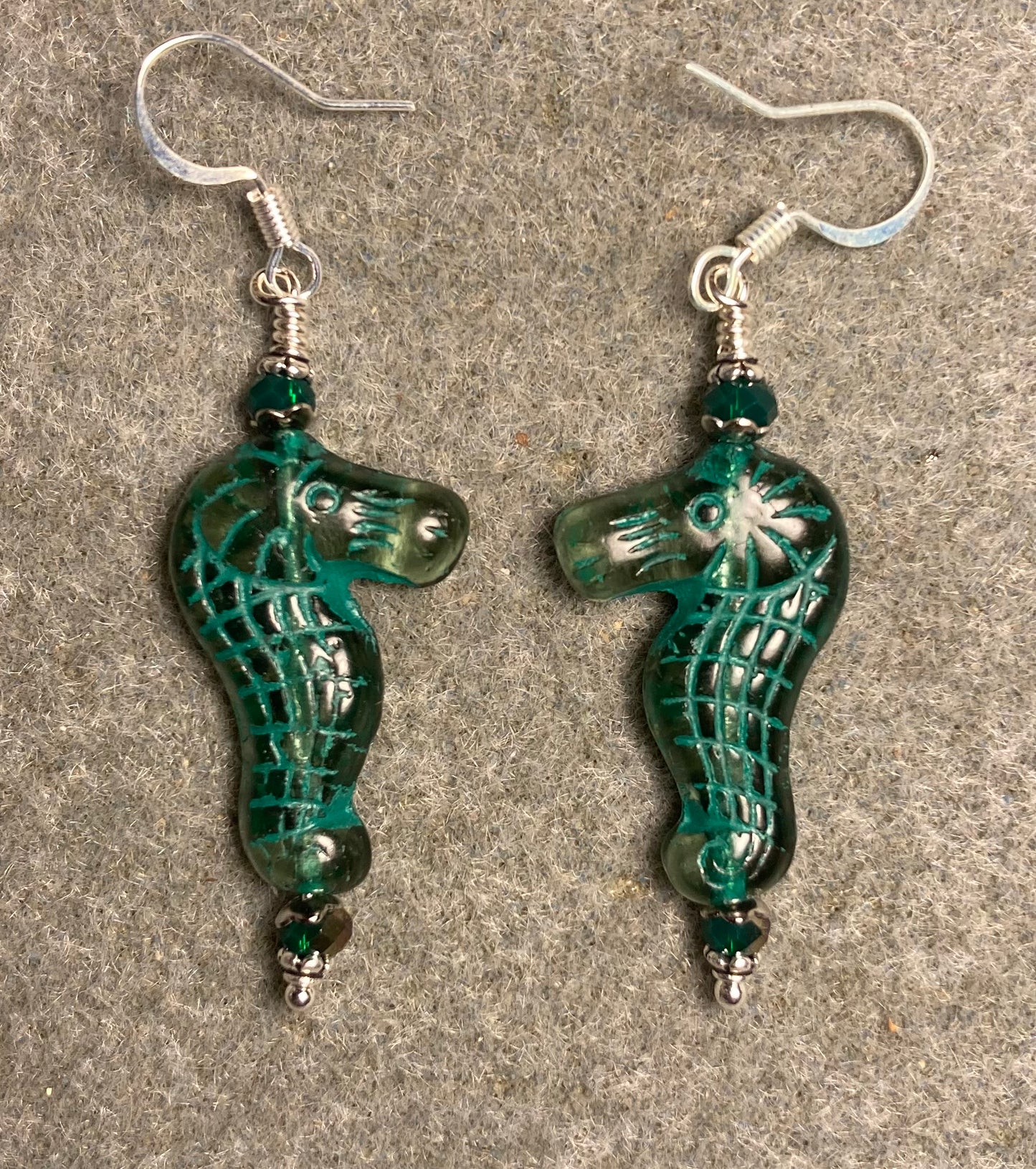 Green (with dark green inlay) Czech glass seahorse bead earrings adorned with dark green Chinese crystal beads.