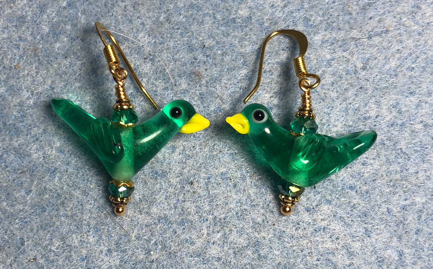 Translucent teal lamp work songbird bead earrings adorned with teal Chinese crystal beads.