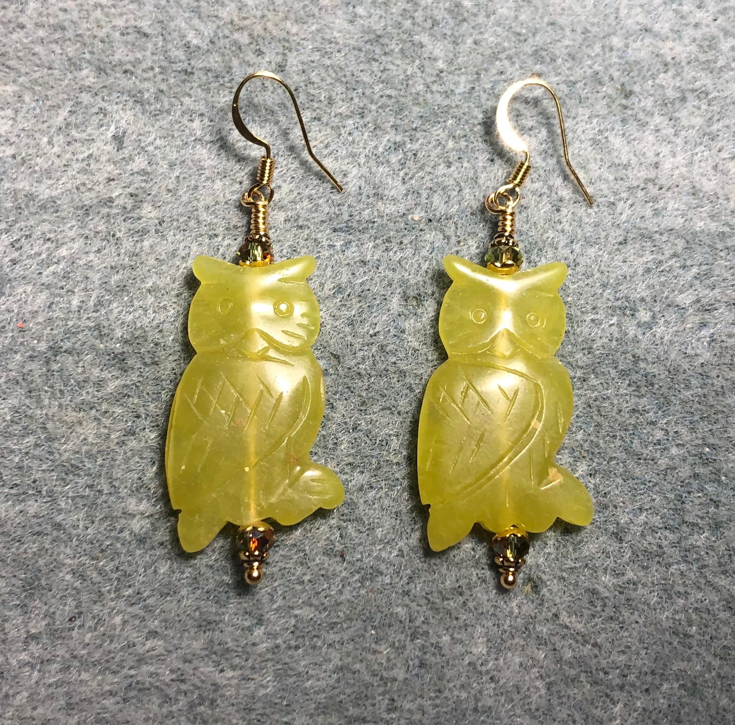 Large green serpentine gemstone owl bead earrings adorned with olive green Chinese crystal beads.
