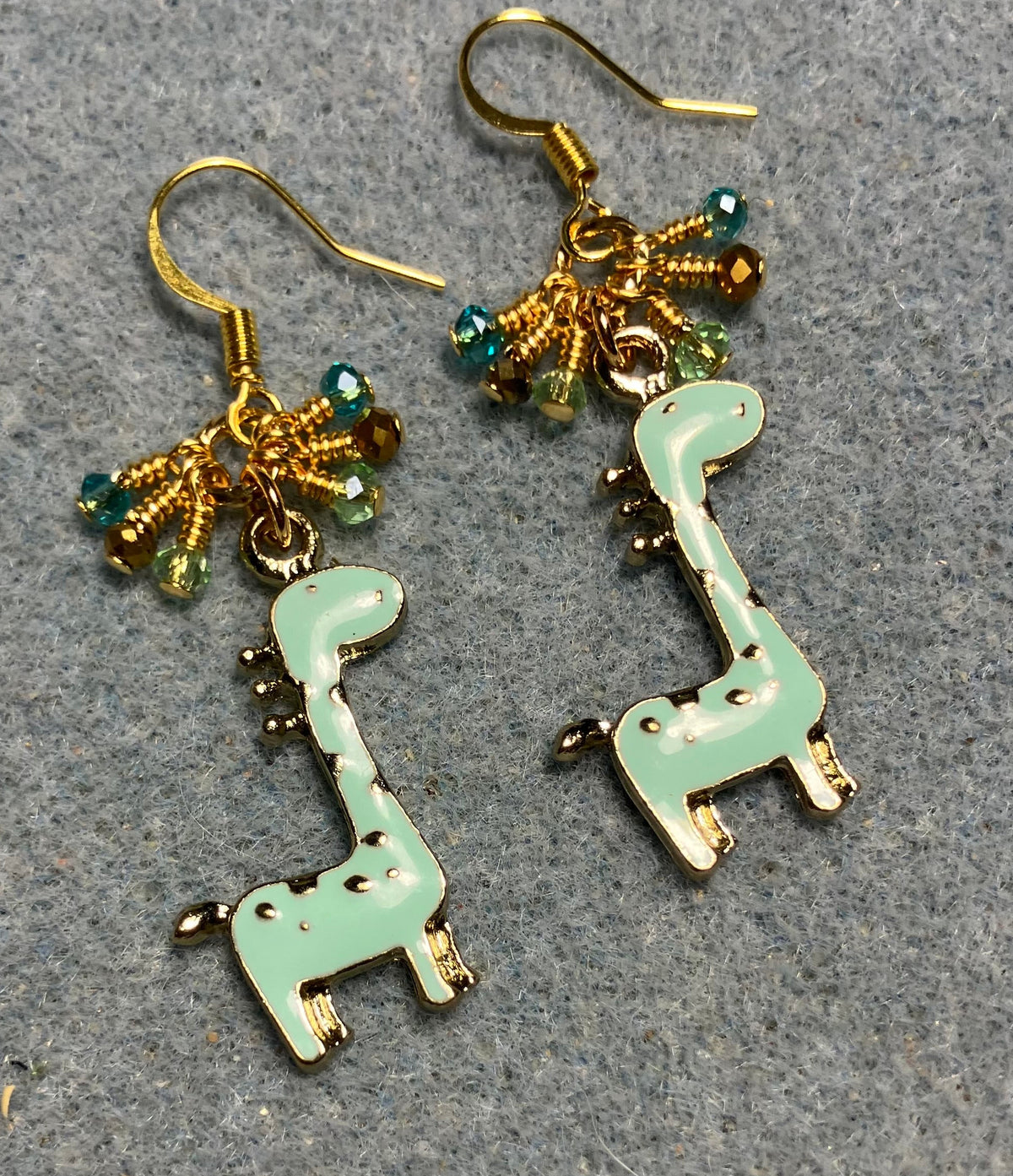 Light aqua enamel spotted giraffe charm earrings adorned with tiny dangling aqua, gold, and light green Chinese crystal beads.