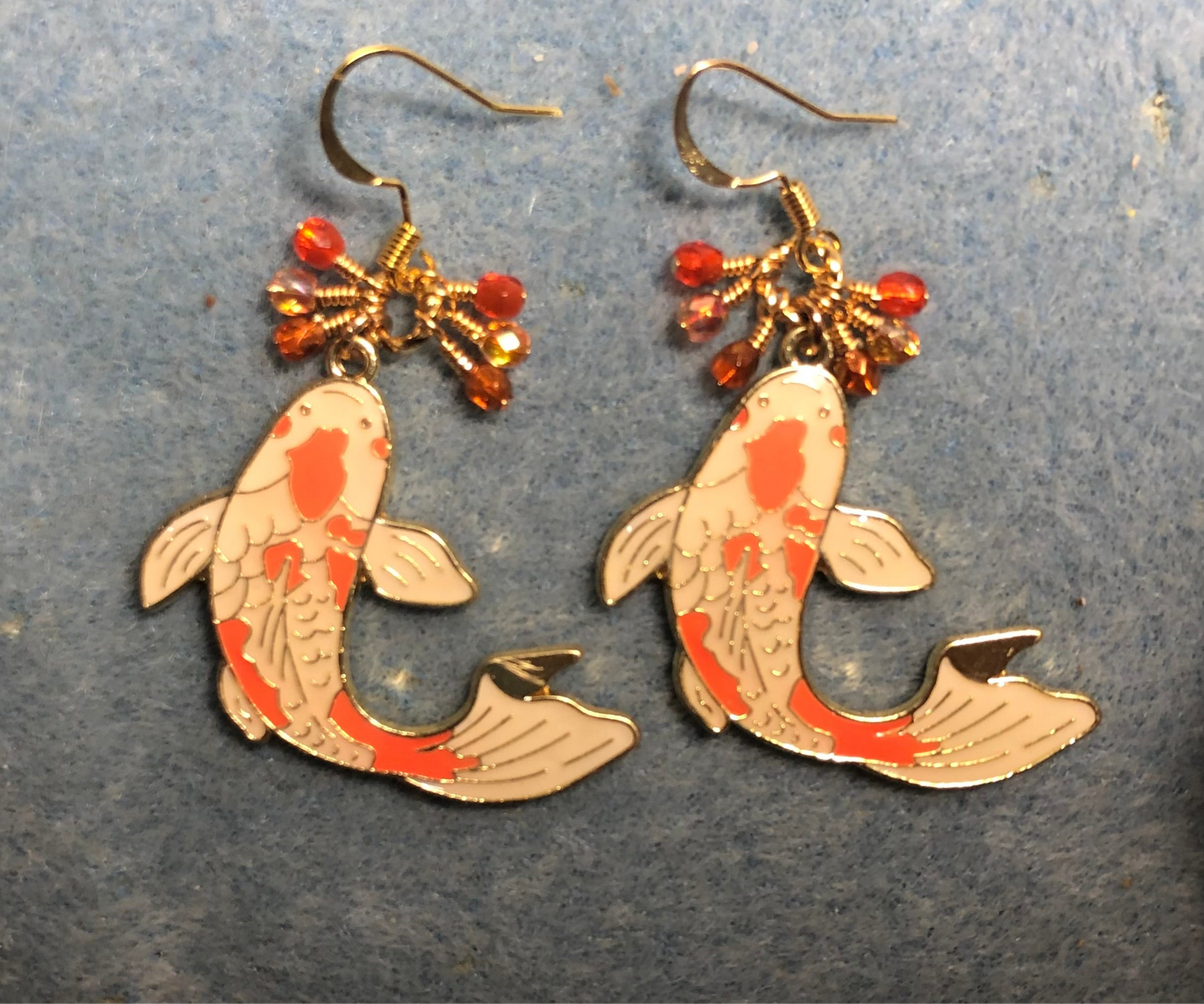 Large orange and white enamel koi charm earrings adorned with tiny dangling orange Czech glass beads.