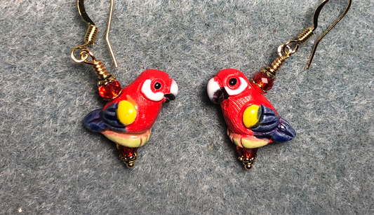 Small red, blue, and yellow ceramic parrot bead earrings adorned with red Chinese crystal beads.