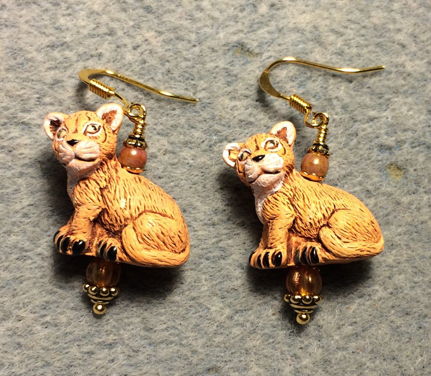 Orange ceramic lion cub bead earrings adorned with orange Czech glass beads.